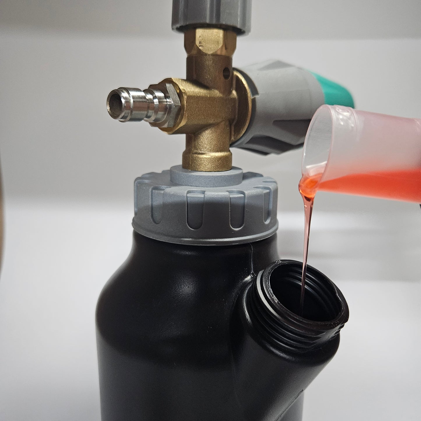 Een persoon giet een vloeistof in een Molat-winkel Schuimkanon 1L pro-container.